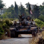 Syrian army tanks take position at the road during a patrol to pursuit of opposition fighters