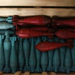 Improvised mortar shells that are colored are seen inside a box at a weapons factory in Aleppo