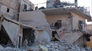 A woman inspects her damaged home in Aleppo