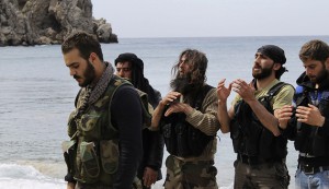 Rebel fighters pray at the beach of al-Samra in Latakia province near the town of Kasab