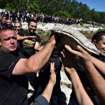 Volunteers and police officers pass sand