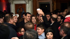 Syrian President Bashar Assad (C-L) and his wife Asma al-Assad (C-R) posing for a picture with a Syrian man as they attend a Christmas choral presentation at the Lady of Damascus Catholic Church in the Syrian capital on December 18, 2015. © HO / AFP 