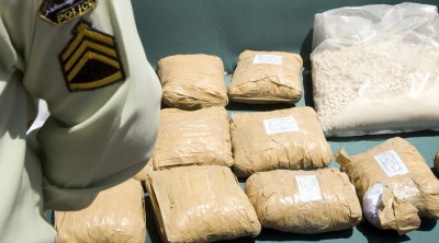 An Iranian anti-narcotics policeman stands guard beside a display of confiscated drugs during a ceremony concluding anti-narcotics manoeuvres in Zahedan, 1,605 kilometers (1,003 miles) southeast of Tehran May 20, 2009. The head of the U.N. crime agency praised Iran during a visit on Wednesday for curbing the flow of smuggled heroin from Afghanistan and helping keep the drug off Western streets. Picture taken May 20, 2009. REUTERS/Caren Firouz (IRAN CRIME LAW POLITICS SOCIETY) - RTXKL1B