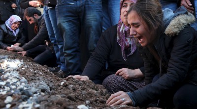 Relatives of Siyar Salman mourn over his grave during a funeral ceremony in the Kurdish dominated southeastern city of Diyarbakir, Turkey, December 15, 2015. According to local media, Salman, a 19-year old man, was killed on Monday in Diyarbakir during a protest against the curfew in Sur district. REUTERS/Sertac Kayar - RTX1YSUN