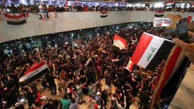 Iraqi protesters wave national flags as they gather inside the parliament after breaking into Baghdad's heavily fortified "Green Zone" on April 30, 2016. (AFP)