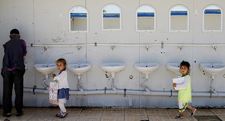 Syrian refugee girls walk past past a public toilet as they go to kindergarten at a refugee camp in Osmaniye, Turkey, May 17, 2016 - REUTERS photo