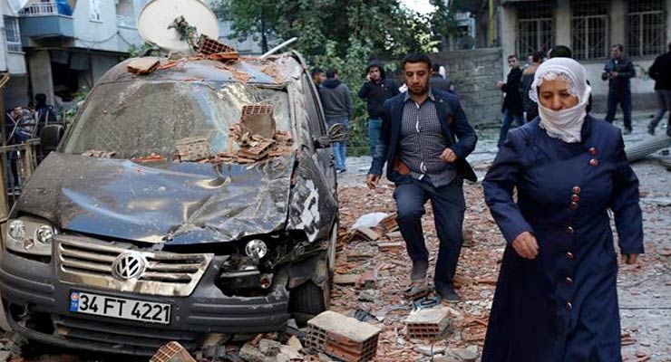 People walk past a damaged car after a blast in the Kurdish-dominated southeastern Turkish city of Diyarbakir, Nov. 4, 2016. (Photo by Reuters)