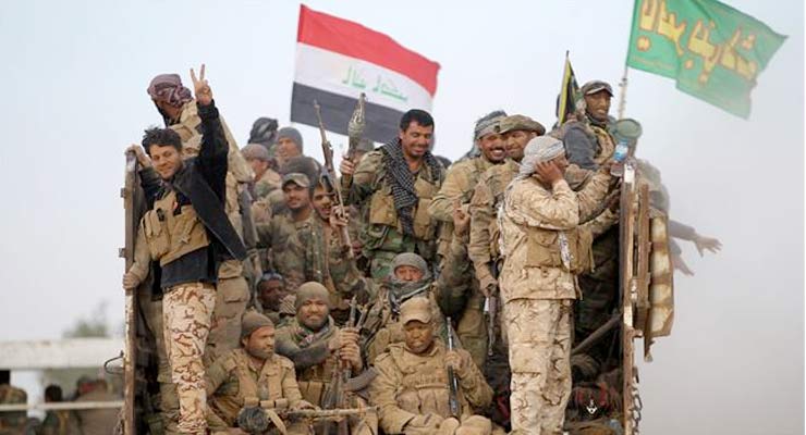 Hashd al-Shaabi fighters flash the sign of victory from the back of a truck as they drive towards the village of Umm Sijan, southwest of Mosul, on October 31, 2016. (Photo by AFP)